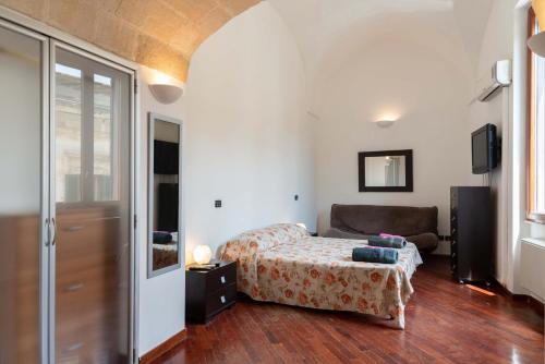 a bedroom with a bed and a couch in a room at ABACA Rooms in Lecce