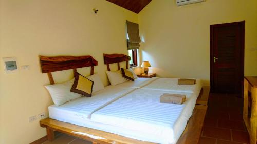 sypialnia z dużym białym łóżkiem w pokoju w obiekcie Wildland Resort w Duong Dong