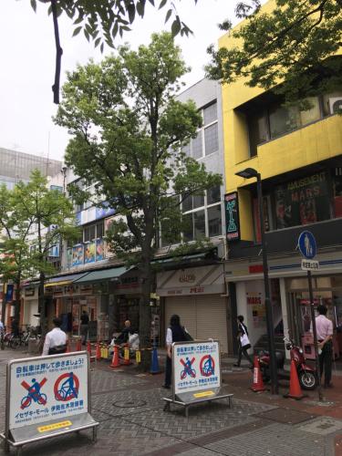a city street with signs in front of buildings at YokohamaKannai HouseBar in Yokohama