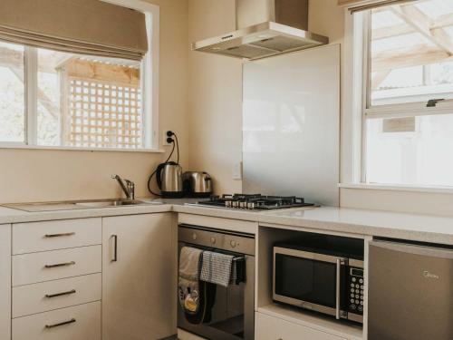 a kitchen with a stove and a microwave at Tongariro Crossing Lodge in National Park