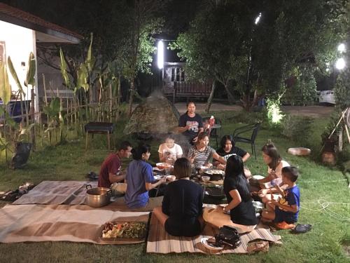 a group of people sitting around a picnic table at Baan Suan Kru Kob in Ban Ko Maphang