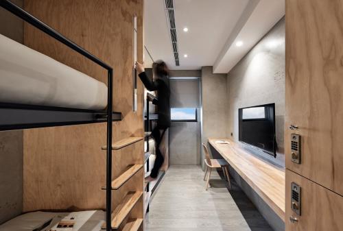 a person standing in a small room with bunk beds at Waterfront Hotel in Taipei