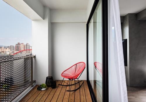 a pair of red chairs sitting on a balcony at Waterfront Hotel in Taipei
