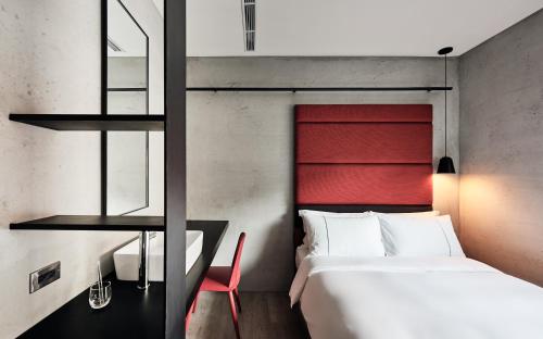 a bedroom with a bed and a red headboard at Waterfront Hotel in Taipei