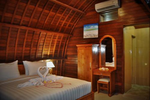 - une chambre avec un lit recouvert d'un cygne dans l'établissement Setilas Bungalows, à Nusa Penida