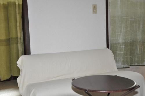 a bed in a room with a white mattress at Tuktuk House in Kawagoe