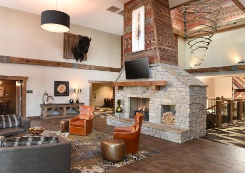 a living room with a large stone fireplace at Stoney Creek Hotel Tulsa - Broken Arrow in Broken Arrow