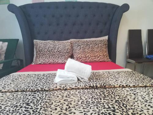 a bed with a black headboard and two white pillows at Nica's Place Property Management Services at Horizons 101 Condominium in Cebu City