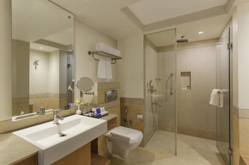 a bathroom with a sink and a toilet and a shower at Park Plaza, Ludhiana in Ludhiana