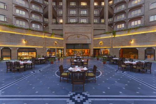 a restaurant with tables and chairs in front of a building at Park Plaza, Ludhiana in Ludhiana