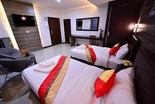 a hotel room with two beds with red and white pillows at The Room Boutique Hotel in Sakon Nakhon