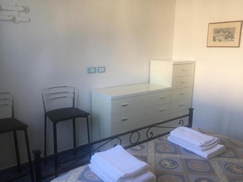 a bedroom with a dresser and two stools at Villa Azzurra in San Felice Circeo