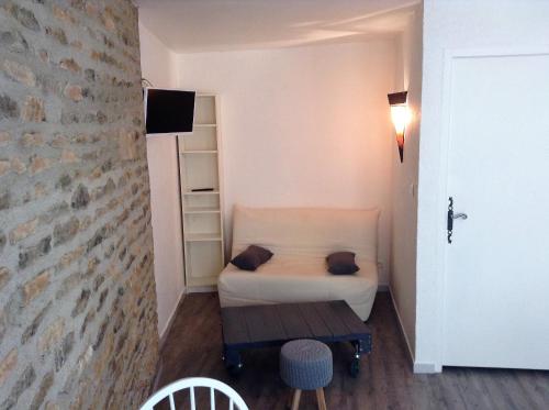 ein kleines Schlafzimmer mit einem Bett und einer Ziegelwand in der Unterkunft Les ramades romanaises - Pas de TV in Saint-Roman-de-Malegarde