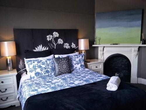 een slaapkamer met een groot bed en een open haard bij Eureka Views B&B Ballarat in Ballarat