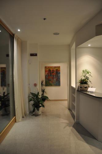 a hallway with potted plants and a painting on the wall at Tullio Hotel in Gravedona