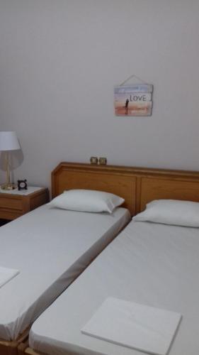 two beds in a room with a sign that reads love at Νatasas Place in Evia in Amarinthos