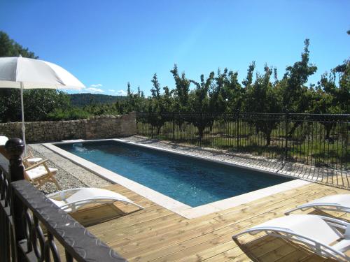 - une piscine avec des chaises et un parasol sur la terrasse dans l'établissement Mas du Moutet, à La Capelle-et-Masmolène