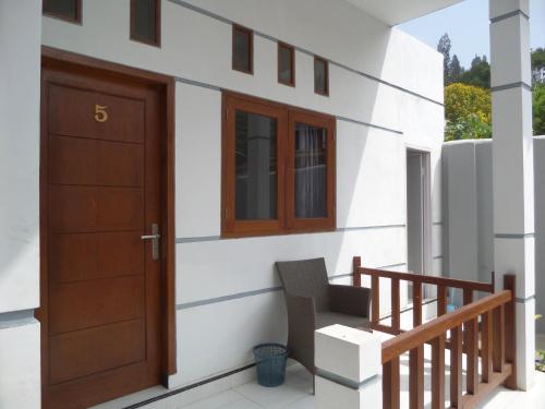 a house with a door and a chair on a balcony at Savana Guesthouse in Bromo