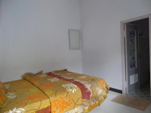 a bedroom with a bed with a colorful blanket at Savana Guesthouse in Bromo