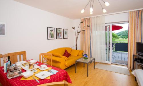 uma sala de estar com um sofá amarelo e uma mesa em Ferienwohnung Streifinger em Freyung