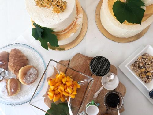 a table with three cakes and bread and other foods at Zuani Casa in San Floriano del Cóllio