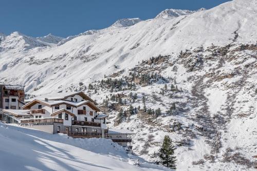 a building on the side of a snow covered mountain at Das Hochegg - Apartments in Obergurgl