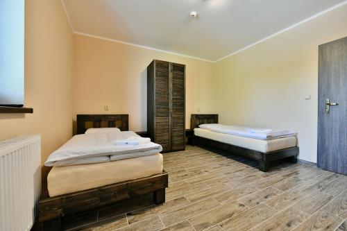 2 Betten in einem Zimmer mit Holzböden in der Unterkunft Wellness Hotel Fridrich in Horní Těrlicko