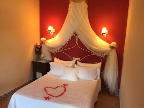 a bedroom with a bed with a heart on it at Hotel Rural Andalucia in Sierra de Yeguas