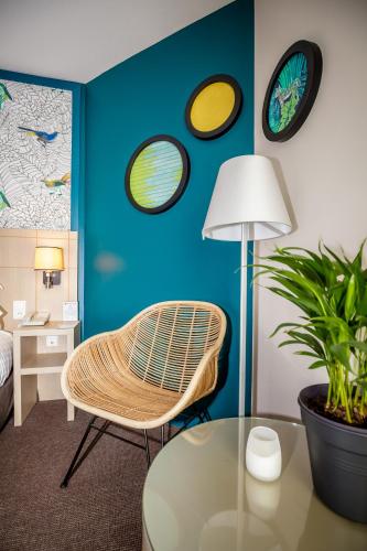 a room with a chair and a glass table at Best Western Plus Hôtel Vannes Centre Ville in Vannes