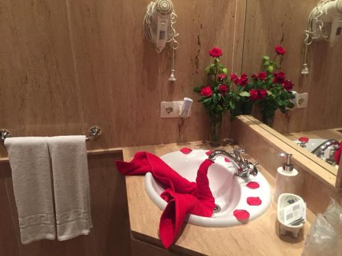 un baño con lavabo con una cinta roja. en Hotel Rural Andalucia, en Sierra de Yeguas