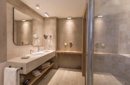 a bathroom with a large sink and a shower at Hotel Grand Relais Dei Nuraghi in Baja Sardinia