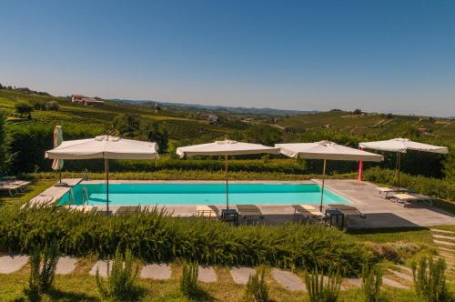 a swimming pool with umbrellas and tables and chairs at Casa LuceSole in Fontanile
