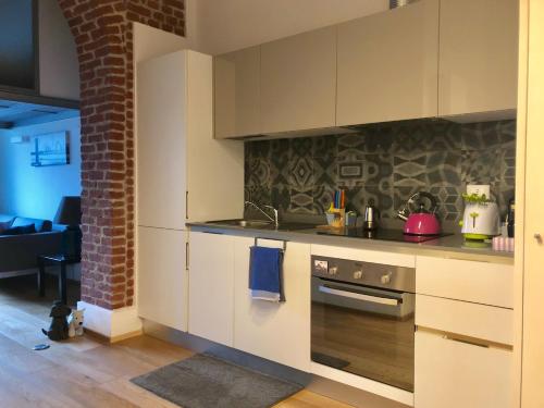 a kitchen with white cabinets and a stove at Lovely Loft Isola/Garibaldi in Milan