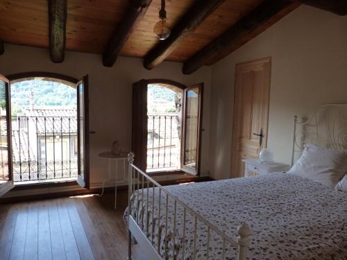 a bedroom with a white bed and two windows at Les Magranes Bed & Breakfast in Argelaguer