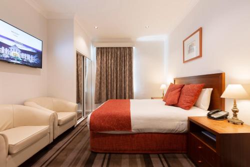 a hotel room with a bed and a couch at Mercure Canberra in Canberra