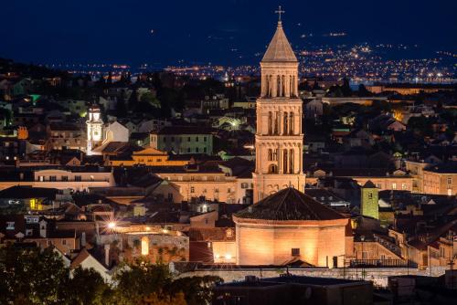 a view of a city at night with a clock tower at Royal Suites-Sky in Split
