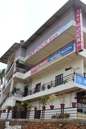 a building with potted plants on the balconies at Skyrock Inn in Kattappana