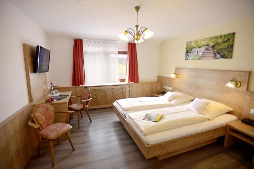 a bedroom with two beds and a table and chairs at Landgasthof Sonne in Alpirsbach