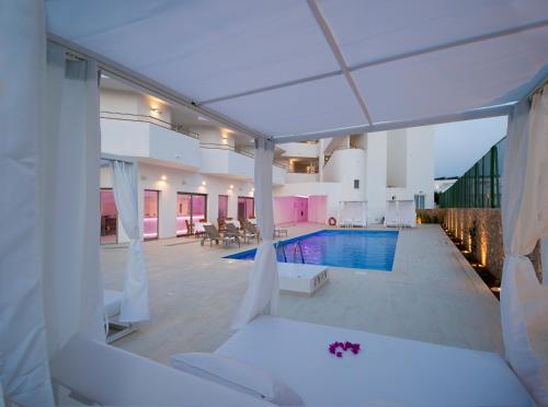 a house with a swimming pool with a white roof at My Way Luxury Ibiza Studio - AB Group in Playa d'en Bossa