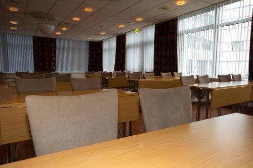 Finnsnes Hotel في فينسنس: قاعة المؤتمرات مع الطاولات والكراسي والنوافذ