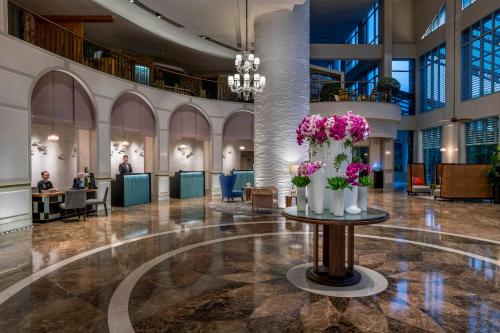 a lobby with a table with flowers on it at Sofitel Saigon Plaza in Ho Chi Minh City