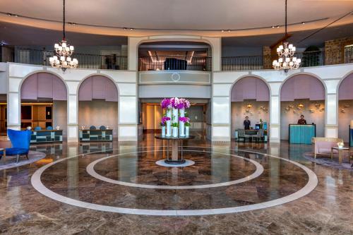 a lobby with a large lobby with flowers in the middle at Sofitel Saigon Plaza in Ho Chi Minh City