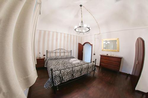 um quarto com uma cama e um lustre em Al Vecchio Cellaio Historical Guest House em SantʼAntonio Abate
