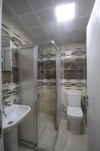 a bathroom with a shower and a toilet and a sink at Zara Palas Otel in Zara