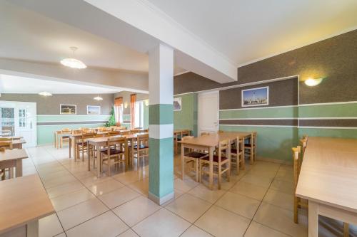 ブダペストにあるシルバー ホテル ブダペスト シティ センターの木製のテーブルと椅子のあるダイニングルーム