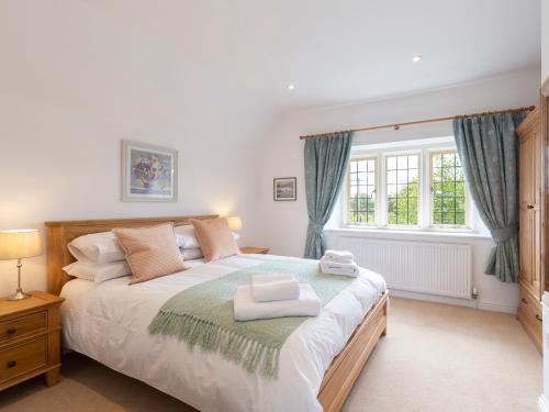 um quarto com uma cama grande e uma janela em Meadow View em Cirencester