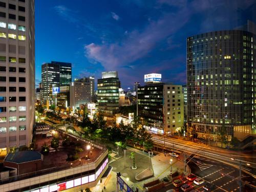 a city skyline at night with buildings and traffic at Hotel Monterey Le Frere Osaka in Osaka