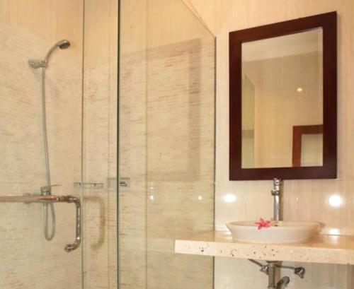 a bathroom with a shower with a sink and a mirror at Villa Anyelir in Seminyak