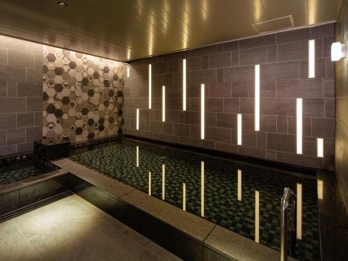 a swimming pool with lights in a building at Hotel Monterey Le Frere Osaka in Osaka