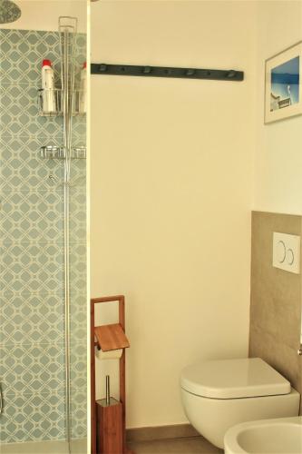 a bathroom with a toilet and a glass shower at La Basiglia B&B in Monforte dʼAlba